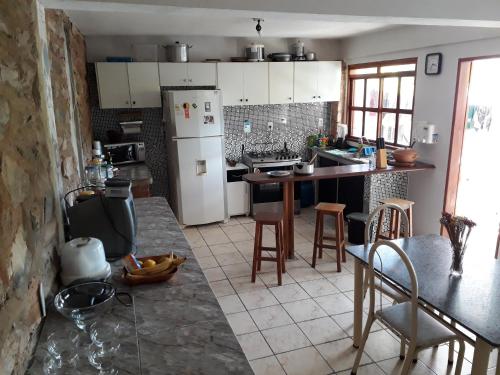 伦索伊斯casa de Luciana - Lençóis的厨房配有冰箱和桌椅