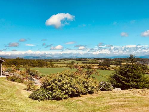 普尔赫利The Piggery - North Wales Retreat的享有树木和房屋的田野景色