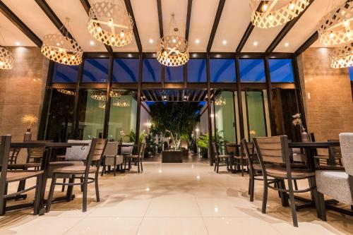 瓦哈卡市Marialicia Suites, Hotel Boutique的餐厅设有桌椅和吊灯。