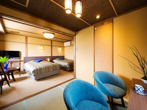 南部町阿萨西罗日式旅馆的一间卧室配有两张床和蓝色的椅子