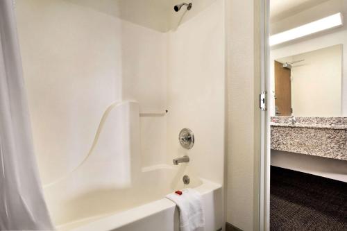 夏延Travelodge by Wyndham Cheyenne的白色的浴室设有浴缸和水槽。