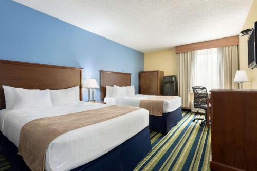 法戈Days Inn by Wyndham Fargo的酒店客房配有两张床和一张书桌