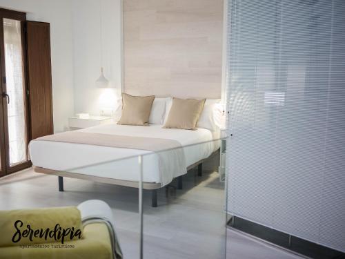 卡塞雷斯Serendipia San Justo的一间卧室设有一张床和玻璃墙