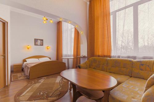 加里宁格勒佐罗塔亚布达酒店的客厅配有沙发、桌子和床。