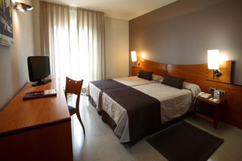 格拉诺列尔斯格拉诺列尔斯酒店的酒店客房配有一张床、一张书桌和一台电视。