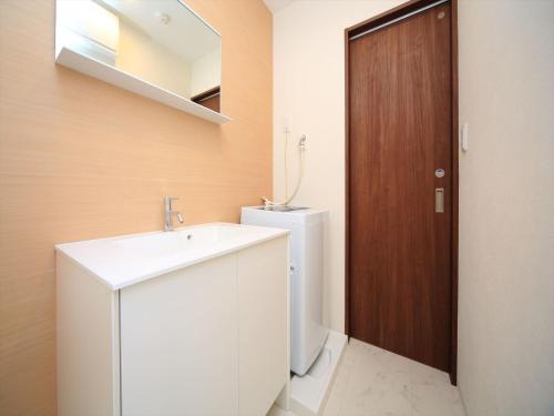 东京东京古都涩谷4公寓的一间带水槽和卫生间的浴室以及一扇木门。