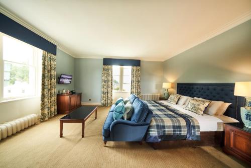 奈恩克瑞拉高尔夫景酒店&SPA的一间卧室配有一张床和一张蓝色椅子