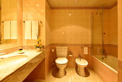 丰沙尔Pestana Village Garden Hotel的浴室配有卫生间、盥洗盆和浴缸。