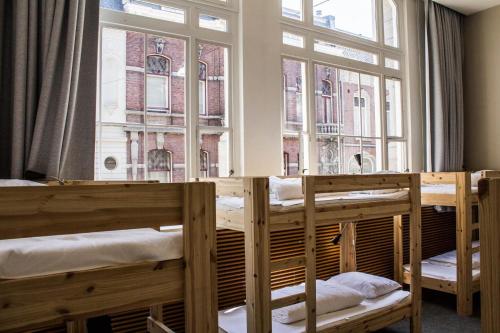 蒂尔堡Hostel Roots的一组双层床,位于一个窗口的房间