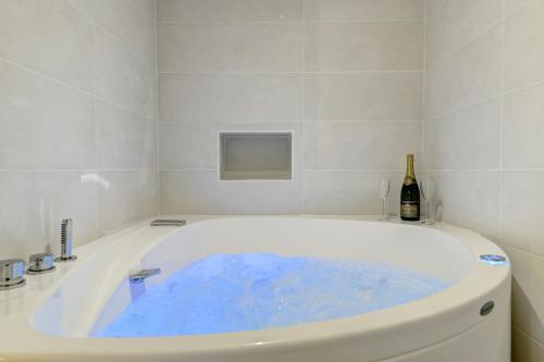 图卢兹My Toul'House SPA的浴室设有装满蓝色水的浴缸。