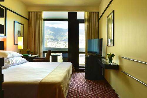 丰沙尔佩斯塔纳赌场公园酒店&赌场的酒店客房设有一张床和一个大窗户