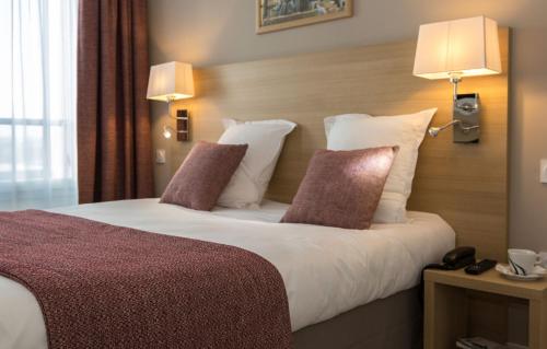 南特Résidence Odalys Nantes Cité des Congrès的酒店客房 - 带一张大床和两个枕头