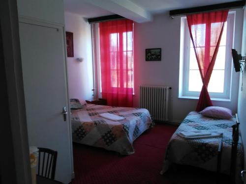 AigurandeLe Relais De La Marche的客房设有两张床和一个带红色窗帘的窗户。