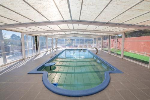 特鲁埃尔Casa El Mirador的一座大型游泳池,位于一座带窗户的建筑内