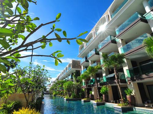 芭东海滩Phuket Graceland Resort and Spa的前面有一条河流的酒店