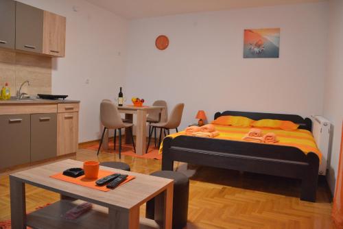 弗尔尼亚奇卡矿泉镇Apartman Radmanovac的一间卧室配有一张床,厨房配有桌子