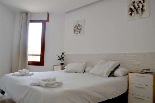 法纳贝海滩Apartamento en Viña del Mar的卧室配有白色床和毛巾