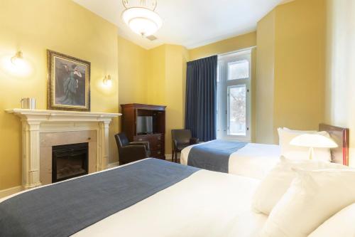 魁北克市格林奥乐酒店的酒店客房设有两张床和壁炉