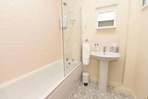 巴利卡斯尔Causeway Coast Apartments Kyla Marine的白色的浴室设有水槽和淋浴。