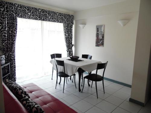 安托法加斯塔Apart Antofagasta的一间配备有白色桌子和黑色椅子的用餐室