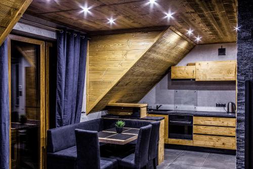 什恰夫尼察Apartament Mountain Chalet的厨房设有木制天花板和桌椅