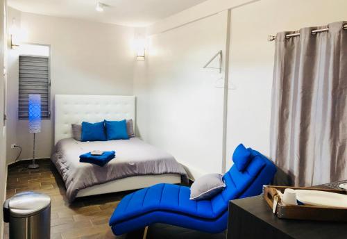 阿瓜迪亚Modern Suite #0 - best location的一间卧室配有一张床和一张蓝色椅子