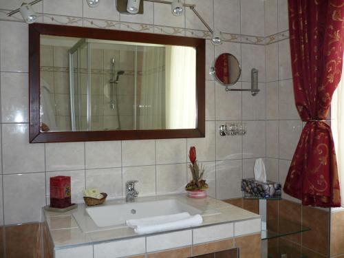 Csepreg老磨坊酒店的一间带水槽和镜子的浴室
