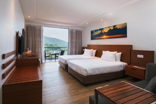 峇都丁宜海湾度假酒店的酒店客房设有两张床和一个阳台。