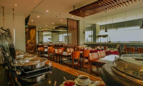泗水泗水高级商务酒店的餐厅设有1间带桌椅的用餐室