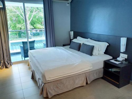 瓜埠G Langkawi Motel的一间卧室设有一张大床和一个大窗户