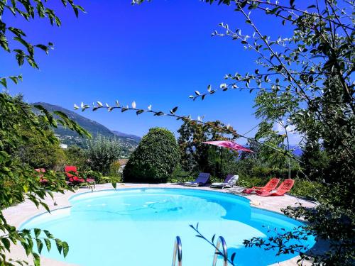 拉戈德Villa Côte d'Azur piscine privée的度假村内的游泳池,配有椅子和遮阳伞
