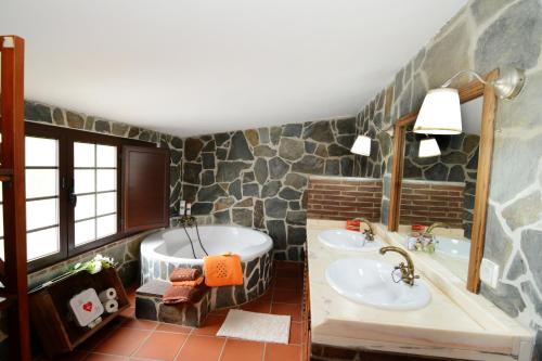 坎普马约尔Moinho da Capela的浴室配有两个盥洗盆和浴缸。
