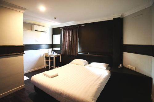 新加坡HOTEL JJH Aliwal的配有一张床和一张书桌的酒店客房