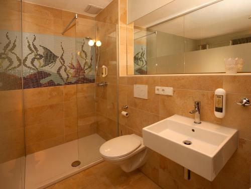 诺德林根Bed and Breakfast unter den Linden的浴室配有卫生间、盥洗盆和淋浴。