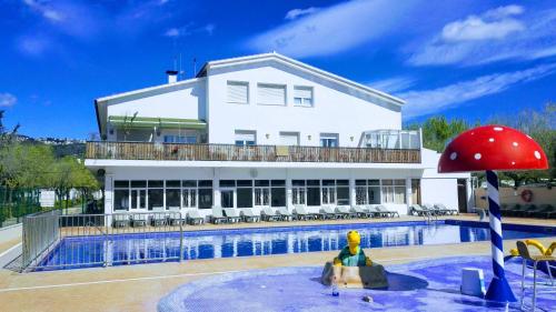 皮内达德马尔Camping Sènia Caballo de Mar的一座大型白色建筑,设有游泳池和房屋