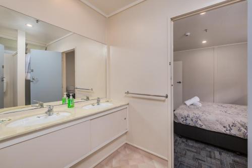 派西亚Riverside Lodge Paihia的一间带水槽、床和镜子的浴室