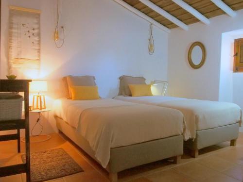 雷东多Monte do Alentejo | Cozy Cottage的白色客房的两张床,配有黄色枕头