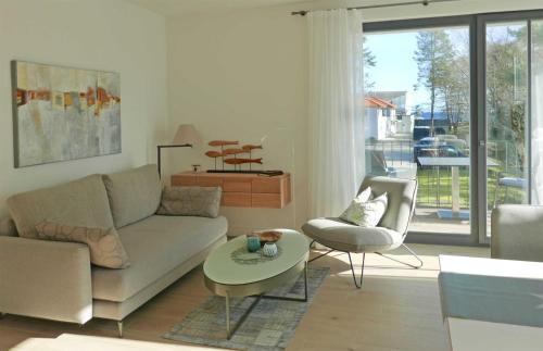 巴贝Baabe Villa Andrea Ferienwohnung M的客厅配有沙发和桌椅