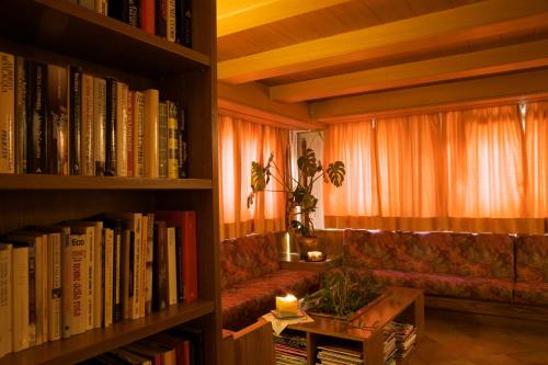 卡拉诺艾尔伯格贝拉利雅酒店的带沙发、桌子和书籍的客厅
