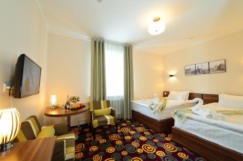 博罗沃耶Konfor Hotel Burabay的酒店客房设有两张床和一张桌子。