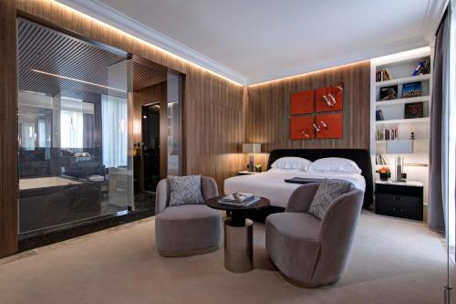 罗马The First Dolce - Preferred Hotels & Resorts的一间卧室配有一张床、两把椅子和一张桌子