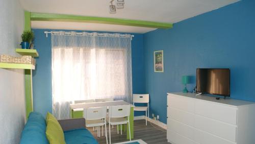 帕斯底拉卡萨孔苏埃格拉公寓的客厅设有蓝色的墙壁、桌子和电视。