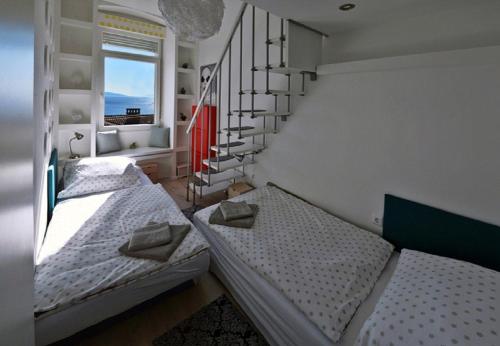 里耶卡Aurora Apartment的配有两张单人床的客房,设有楼梯