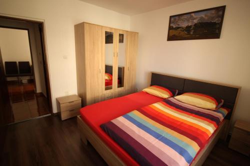 普雷代亚尔Orion的一间卧室配有一张带彩色条纹毯子的床