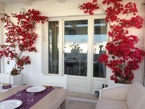 滨海波利尼亚诺多娜帕斯卡住宿加早餐旅馆的一间用红色鲜花装饰的用餐室和一张桌子