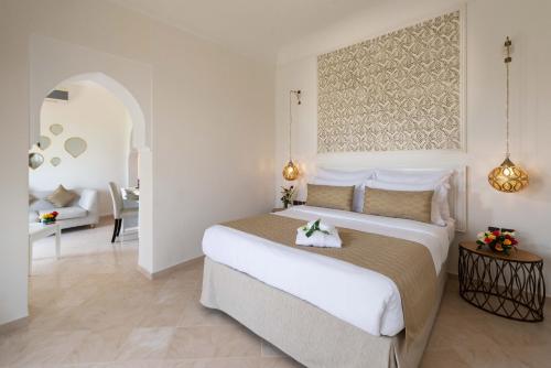 马拉喀什Marrakech Ryads Parc All inclusive的一间带大床的卧室和一间客厅