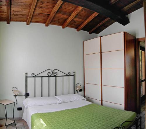 皮耶迪卢科Residence Albornoz的一间卧室配有一张带绿毯的床