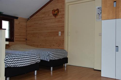 Duffel“利特尔·约翰”假日旅馆的一间卧室设有一张床和木墙