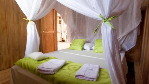 莱蒂西亚La Ceiba, Amazonas的一间卧室配有一张带天蓬和毛巾的床