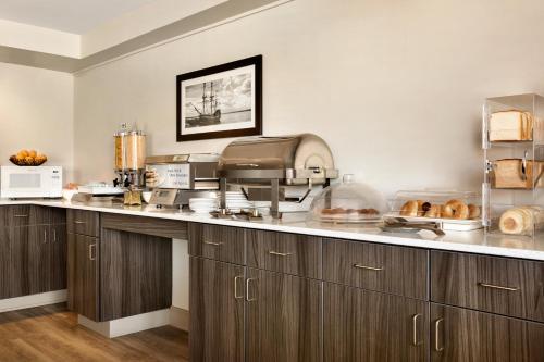 新格拉斯哥Travelodge Suites by Wyndham New Glasgow的厨房配有木制橱柜和食品台面